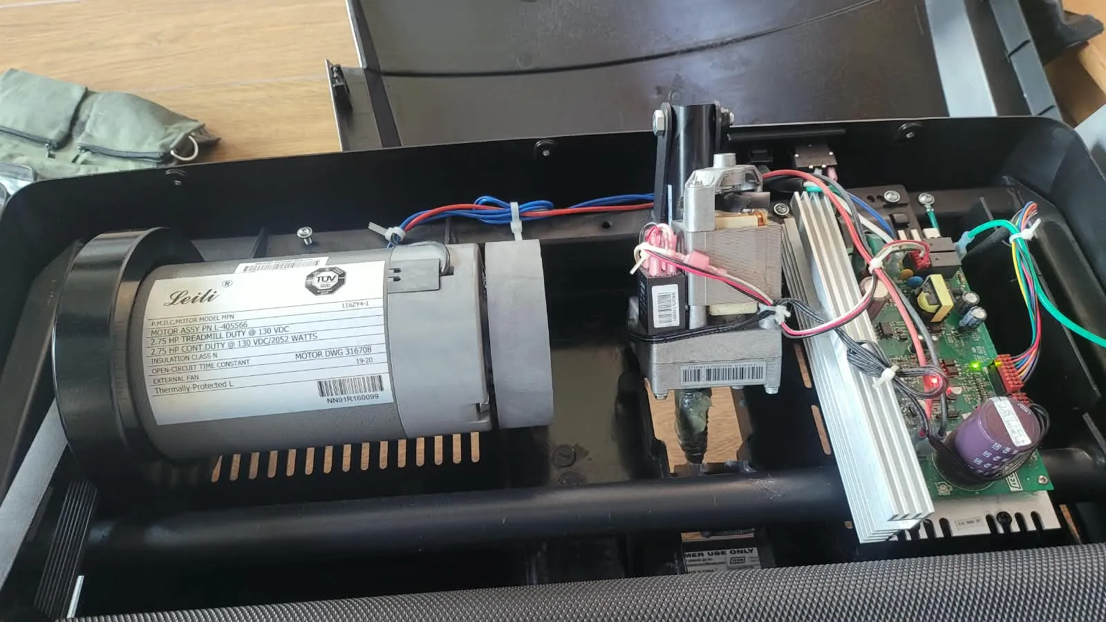 Motor y tarjeta de control de una caminadora con la cubierta retirada